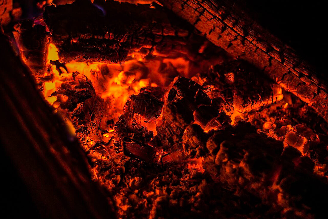Glowing embers in a dark fire pit