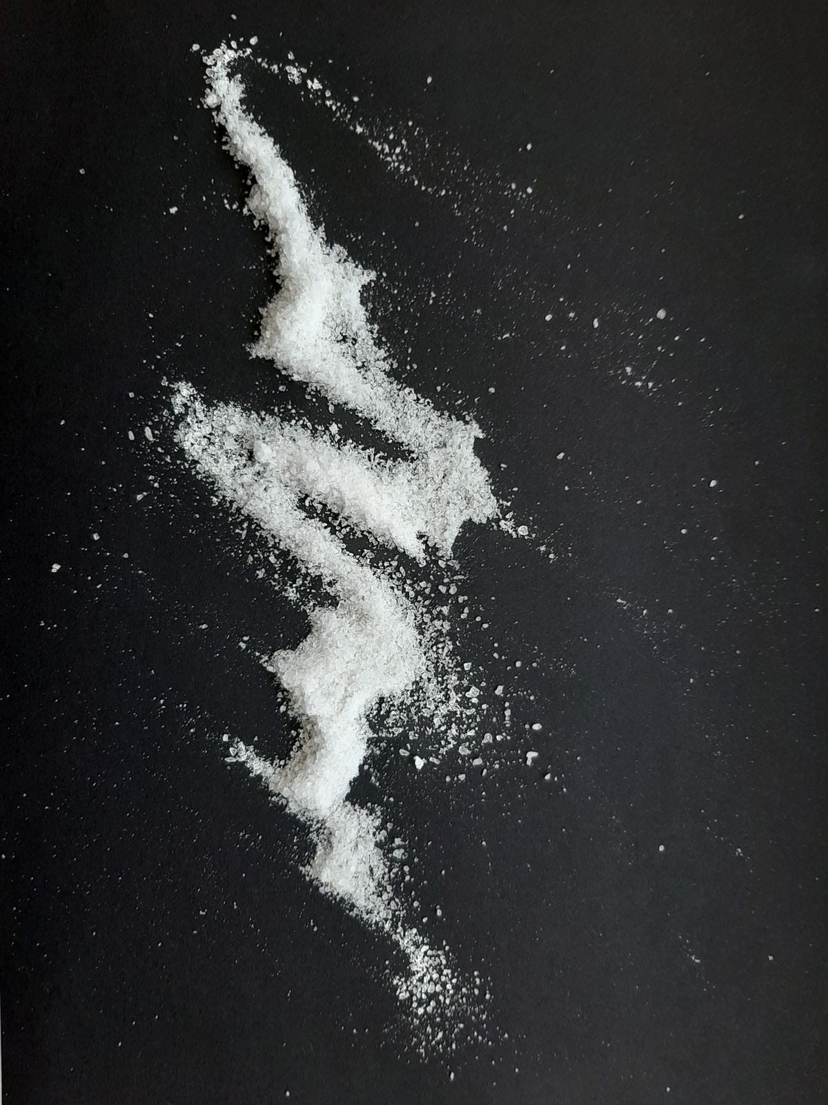 White magnesium powder scattered on a black surface