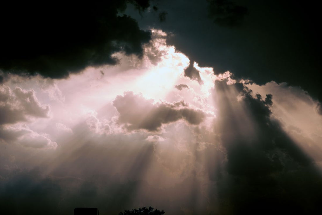 Sunlight breaking through dark storm clouds