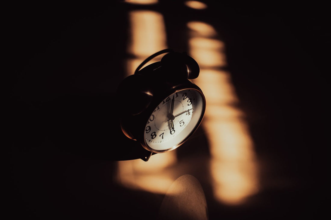 Alarm clock in a darkened room lit by a narrow strip of low evening light
