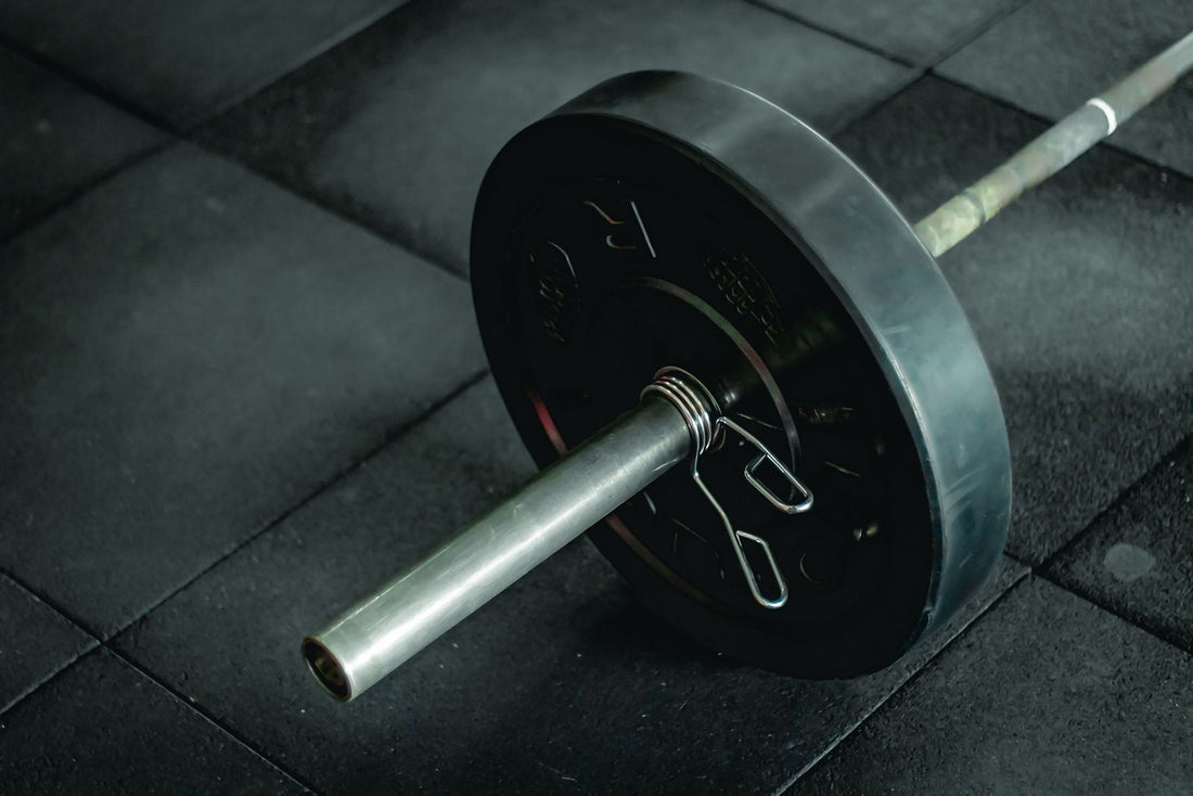 Loaded barbell resting on a dark gym floor, creatine for women over 30