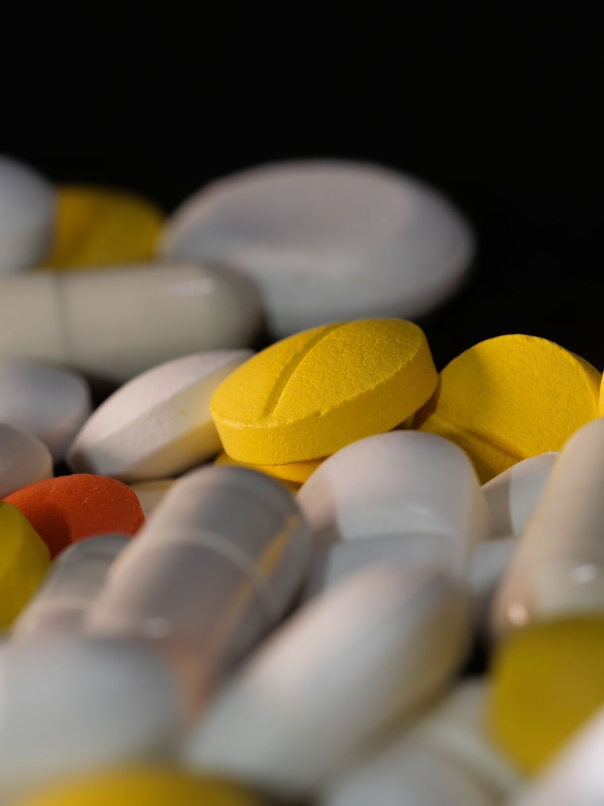 Coloured pills and capsules on a dark surface