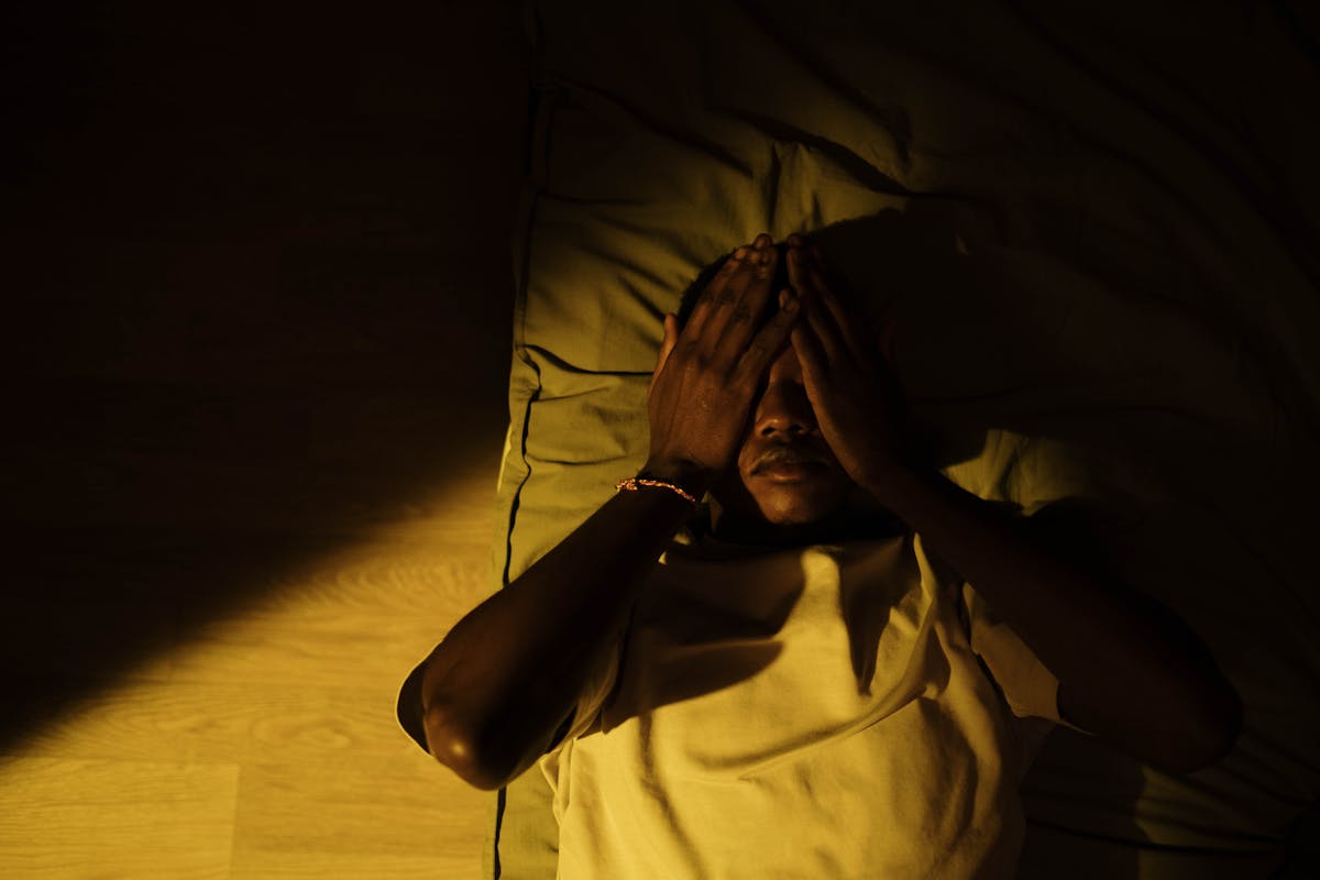 man lying in dark bedroom