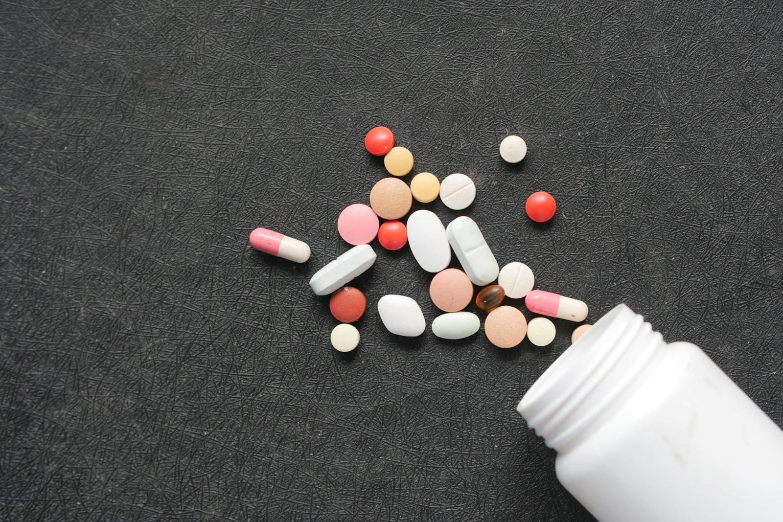 Various medication pills scattered on a dark surface, illustrating supplement label red flags and the gap between marketing and what's actually in the bottle